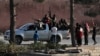 In this photo taken from the Turkish side of the border between Turkey and Syria, in Akcakale, Sanliurfa province, southeastern Turkey, Turkish-backed Syrian opposition fighters celebrate in Tal Abyad, Syria, Sunday, Oct. 13, 2019. State-run Anadolu…