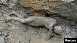 A newly discovered 2,300-year-old bronze statue lies on the ground in San Casciano dei Bagni, Italy, in this handout photo obtained by Reuters on November 8, 2022. (Ministero della Cultura/Handout via REUTERS)