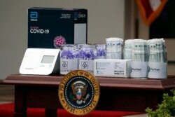 Materials for COVD-19 testing from Abbott Laboratories, U.S. Cotton, and Puritan are displayed as President Donald Trump speaks about the coronavirus during a press briefing in the Rose Garden of the White House, May 11, 2020.