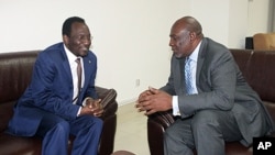 Dioncounda Traore (L), the new interim leader talks with Cheick Mohamed Abdoulaye Souad, aka Modibo Diarra, new prime minister, in Koulouba. Mali's former junta arrested two more politicians as the new interim prime minister weighs the make-up of a unity 