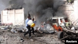 Des agents de sécurité somaliens tentent d'éteindre un incendie sur les lieux d'une explosion près de l'aéroport de la capitale somalienne Mogadiscio, 3 décembre 2014. (Reuters/ Feisal Omar) 