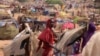 A Sudanese girl who fled the conflict in Sudan's Darfur region, and was previously internally displaced in Sudan, moves past makeshift shelters, near the border between Sudan and Chad, while taking refuge in Borota, Chad, May 13, 2023. 