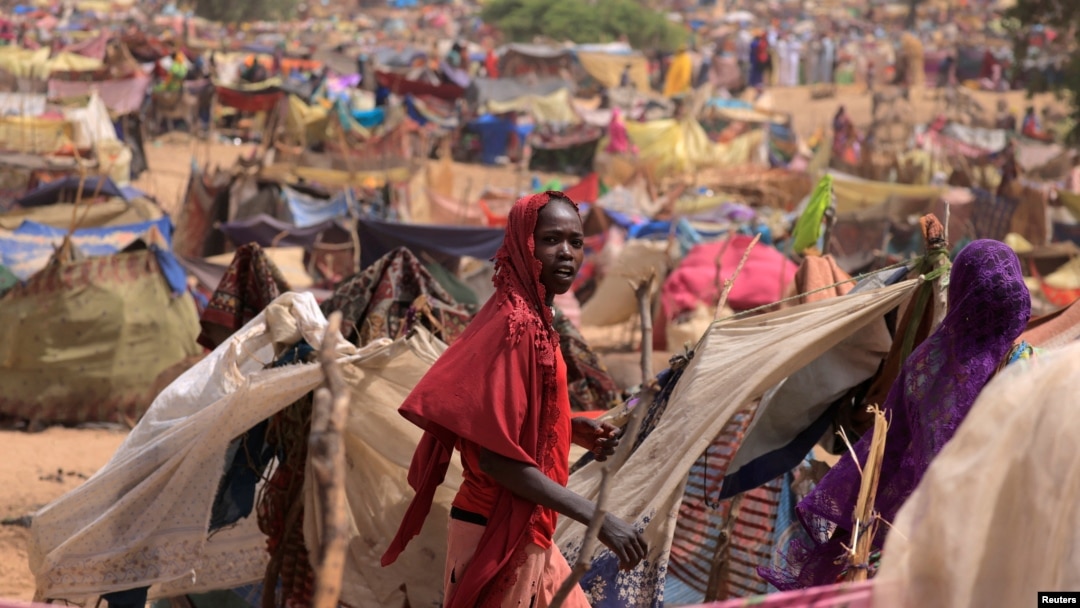 A Sudanese girl who fled the conflict in Sudan's Darfur region, and was previously internally displaced in Sudan, moves past makeshift shelters, near the border between Sudan and Chad, while taking refuge in Borota, Chad, May 13, 2023. 