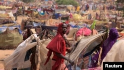 A Sudanese girl who fled the conflict in Sudan's Darfur region, and was previously internally displaced in Sudan, moves past makeshift shelters, near the border between Sudan and Chad, while taking refuge in Borota, Chad, May 13, 2023. 