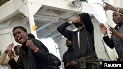 Migrants sing on the deck of MV Aquarius, a search and rescue ship run in partnership between SOS Mediterranee and Doctors Without Borders on their way to Spain, June 16, 2018.