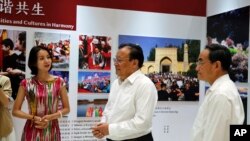 Shohrat Zakir, center, chairman of China's Xinjiang Uighur Autonomous Region, and officials tour a Xinjiang's exhibition before a press conference at the State Council Information Office in Beijing, July 30, 2019. 