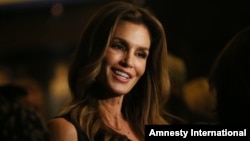 FILE - Model Cindy Crawford poses for photographs on arrival at her book launch at the Beaumont Hotel in central London, Oct 1, 2015. 