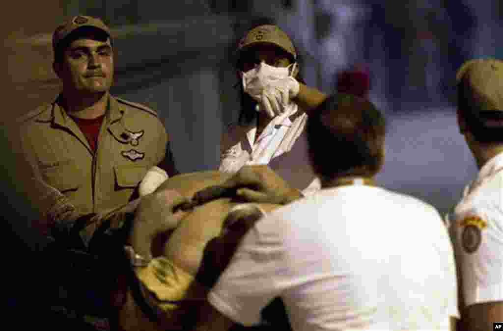 Rescue workers carry an injured victim after a building collapsed in Rio de Janeiro, Brazil. January 25, 2012.