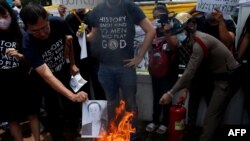 Mahasiswa pro-demokrasi membakar potret Perdana Menteri Thailand Prayuth Chan-o-cha di depan Kantor Pemerintah di Bangkok, Thailand, 24 Juli 2020. (REUTERS/Jorge Silva)