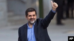 FILE - Jordi Sanchez, president of the Catalan National Assembly, waves to supporters on arrival at the national court in Madrid, Spain, Oct. 16, 2017.