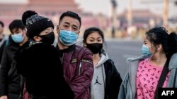 Residentes de Beijing con máscaras para protegerse del nuevo coronavirus cerca de la Plaza de Tiananmen de Beijing el 22 de enero de 2020.