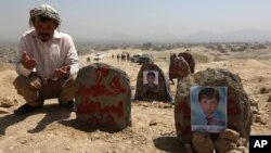 Un afganno ora frente a tumbas de víctimas de un ataque suicida en Kabul, Afganistán, el lunes, 25 de julio de 2016.
