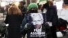 Pendukung pendiri WikiLeaks, Julian Assange, memegang plakat di depan Pengadilan Old Bailey, di London, Inggris, 4 Januari 2021. (REUTERS/Henry) Nicholls