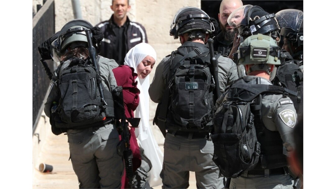 Israeli security force members detain a Palestinian woman during a demonstration held by Palestinians to show their solidarity amid Israel-Gaza fighting, at Damascus Gate just outside Jerusalem's Old City, May 18, 2021.
