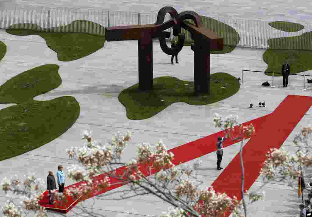 German Chancellor Angela Merkel and the Prime Minister of India Narendra Modi, left, listen to their national anthems during a welcoming ceremony before a meeting at the chancellery in Berlin, Germany.