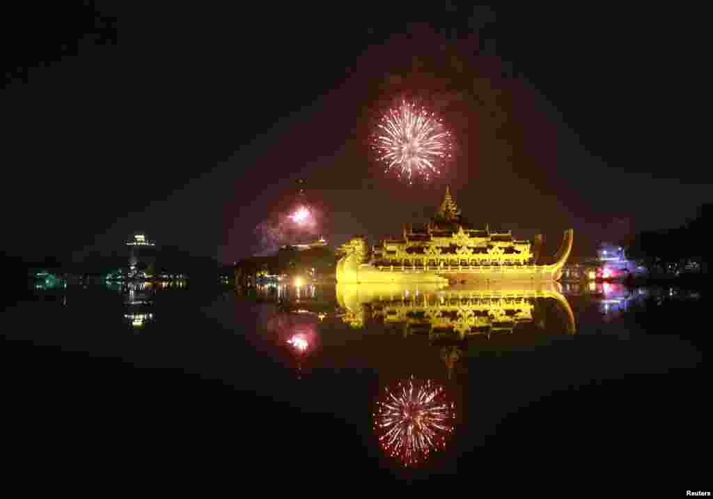 Fireworks explode in the skies above Kayawait palace hotel as people usher in the new year during a 2014 new year&#39;s count down party in Rangoon, Burma.