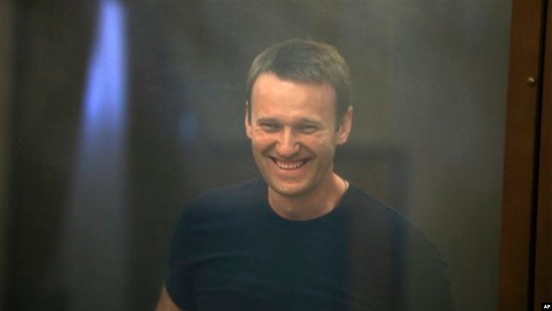 Pemimpin oposisi Rusia Alexei Navalny, terlihat tersenyum dari balik jendela teralis di pengadilan Kirov, Rusia (19/7). Pengadilan membebaskan Navalny sambil menunggu pengajuan banding atas hukuman penjara lima tahun terkait korupsi.