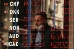 A man is reflected at a foreign currency board in a currency exchange shop, in Istanbul, Turkey, March 22, 2021.