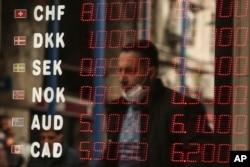 A man is reflected at a foreign currency board in a currency exchange shop, in Istanbul, Turkey, March 22, 2021.