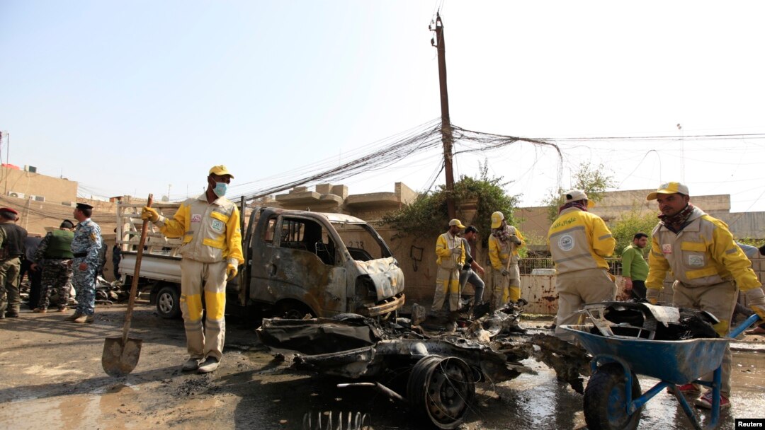 Municipality workers clean the site of a bomb attack in Baghdad, March 5, 2014.