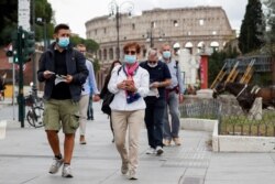 People wear face masks as local authorities in Rome order face coverings to be worn at all times out of doors in an effort to counter rising coronavirus disease (COVID-19) infections, Oct. 2, 2020.