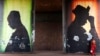 A woman stands in front of a poster in Bamako, Mali, Feb. 21, 2014.