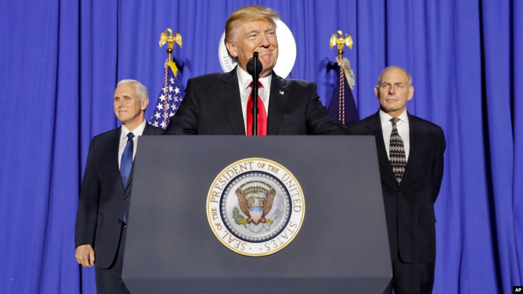 President Donald Trump, accompanied by Vice President Mike Pence, left, and Homeland Security Secretary John F. Kelly, pauses while speaking at the Homeland Security Department in Washington, Jan. 25, 2017. 