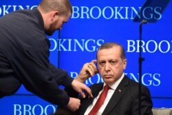 Turkish President Recep Tayyip Ergodan is fitted with an earpiece during an event at the Brookings Institution in Washington, March 31, 2016.