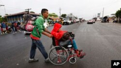 Nicaraguan migrant Javier Velazquez wheels his 14-year-old son across a highway, as part of the Central American migrant caravan hoping to reach the U.S. border, in Acayucan, Veracruz state, Mexico, Nov. 3, 2018. Javier Velazquez said that Axel was shot 