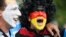 An Argentina and Germany fan with their faces painted in the national colors cheer before the 2014 FIFA World Cup final football match between Germany and Argentina at Maracana Stadium in Rio de Janeiro, Brazil.
