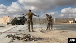 在伊拉克西部的安巴爾省阿薩德空軍基地，在美國領導的聯軍組織媒體參觀期間，美軍士兵清理伊朗導彈襲擊後造成的廢墟。(2020年1月13日)