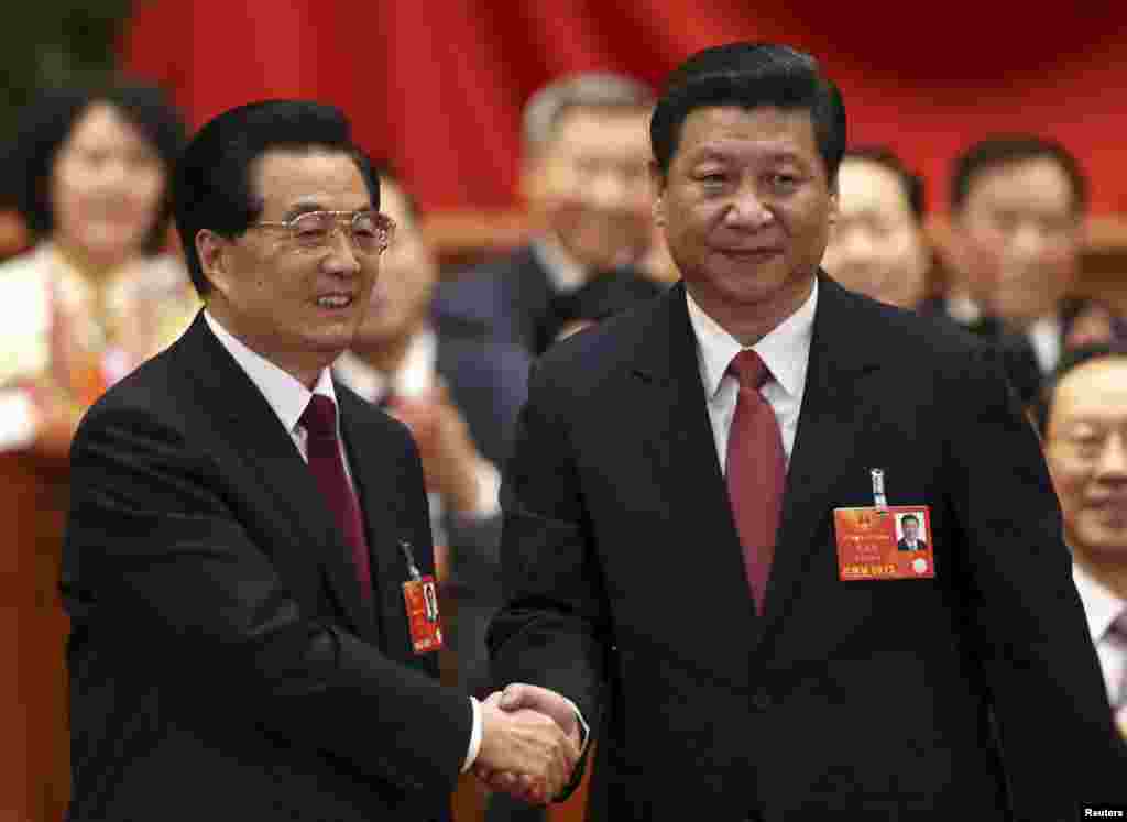 Hu Jintao shakes hands with China's newly elected President and chairman of the Central Military Commission Xi Jinping during the fourth plenary meeting of the first session of the 12th National People's Congress (NPC) in Beijing, March 14, 2013. 