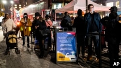 FILE - People wait to receive a COVID-19 vaccine booster shot at a mobile vaccination site near Central Park in New York City, Dec. 2, 2021. 