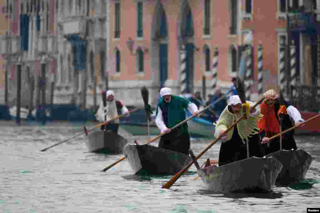 Men dressed as &quot;La Befana&quot;, an imaginary old woman who is thought to bring gifts to children, row boats down the Grand Canal in Venice, Italy, during the festival of Epiphany.