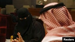 FILE - Saudi woman Fawzia al-Harbi, a candidate for local municipal council elections, gestures to one of her chaperones at a shopping mall in Riyadh, Nov. 29, 2015.