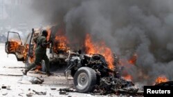 Polisi Somalia berlari ke lokasi bom mobil yang meledak dekat istana Presiden di Mogadishu, Somalia, Senin (18/3). 