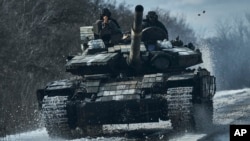 Ukrainian soldiers ride atop a tank in the frontline in Bakhmut, Donetsk region, Ukraine, Feb. 20, 2023.