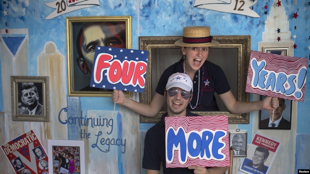 Stephen Kimel and his wife Greta Kimel attract costumers to take pictures at their photo booth which was set-up at a street festival for convention goers ahead of the Democratic National Convention in Charlotte, North Carolina, September 3, 2012. 