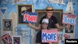 Stephen Kimel and his wife Greta Kimel attract costumers to take pictures at their photo booth which was set-up at a street festival for convention goers ahead of the Democratic National Convention in Charlotte, North Carolina, September 3, 2012. 