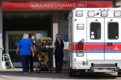 FILE - A LifeLine Ambulance arrives at the CHA Hollywood Presbyterian Medical Center in Los Angeles, Jan. 5, 2021. Many California hospitals are straining under unprecedented caseloads.