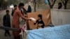 Displaced Afghans distribute food donations at an internally displaced persons camp in Kabul, Afghanistan, Sept. 13, 2021. 