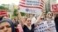 FILE PHOTO: Protesters hold signs against U.S. President Donald Trump's limited travel ban, approved by the U.S. Supreme Court, in New York City, on June 29, 2017.