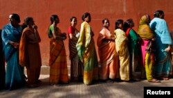 FILE - Women line up to cast their votes outside a polling station during the seventh phase of India's general election at Howrah district in the eastern Indian state of West Bengal, April 30, 2014. 
