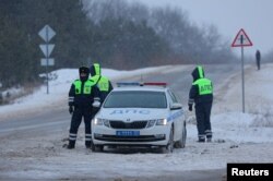 Polisi lalu lintas berjaga di jalan dekat lokasi jatuhnya pesawat angkut militer Ilyushin Il-76 Rusia di luar desa Yablonovo, wilayah Belgorod, Rusia, 24 Januari 2024. (REUTERS/Stringer)