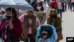 Peruanos hacen fila para hacerse exámen y vacunas en un centro de salud improvisado en una calle del centro de Lima el 5 de enero de 2022.