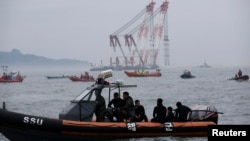 Sewol တောင်ကိုရီးယားသင်္ဘောနစ်မြုပ်နေတဲ့ထဲက ပိတ်မိနေသူတွေကို ရှာဖွေနေတဲ့ ကယ်ဆယ်ရေးလုပ်ငန်းမြင်ကွင်း။ (ဧပြီ ၁၈၊ ၂၀၁၄)