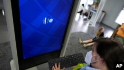 Un técnico elimina el software de una pantalla de información en el Aeropuerto Internacional O'Hare de Chicago, en Chicago, el viernes 19 de julio de 2024, después de que problemas de software retrasaran y cancelaran vuelos a nivel mundial.