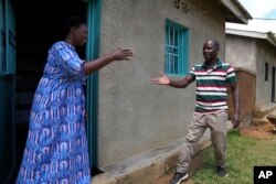 FILE— Genocide survivor Jeanette Nyirabashyitsi, 45, left a Tutsi, greets Frederick Kazigwemo, a Hutu who was jailed for nine years for genocide-related crimes in the reconciliation village of Mbyo, in Nyamata, Rwanda April 5, 2024.