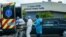 Emergency Medical Technicians (EMT) arrive with a patient while a funeral car begins to depart at North Shore Medical Center where the coronavirus disease (COVID-19) patients are treated, in Miami, Florida, U.S. July 14, 2020. REUTERS/Maria Alejandra Card