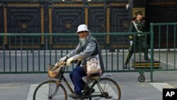 A Chinese man rides his bicycle past the North Korean embassy in Beijing, November 5, 2010.